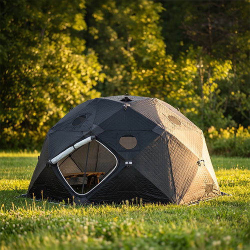 SaunaLife SaunaTrekker XL portable sauna tent set up outdoors in a grassy wooded setting