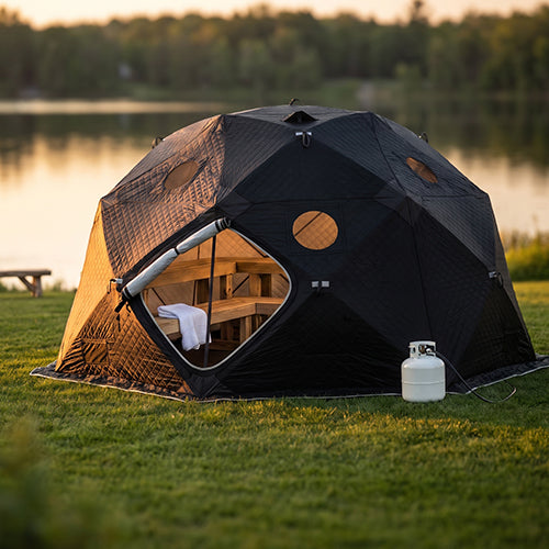 SaunaLife SaunaTrekker XL portable sauna tent with wood benches set up outdoors beside a lake