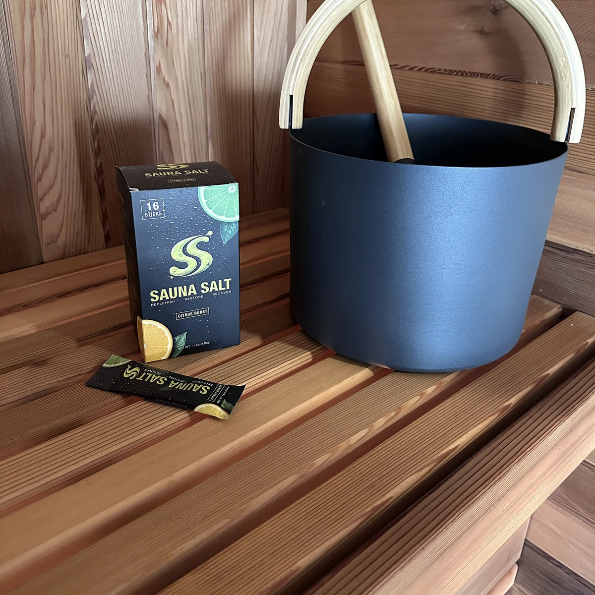 Sauna Salt box and packet beside a sauna bucket and ladle