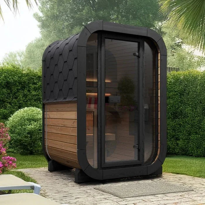 Modern barrel sauna with a black shingle roof and glass door in a garden setting